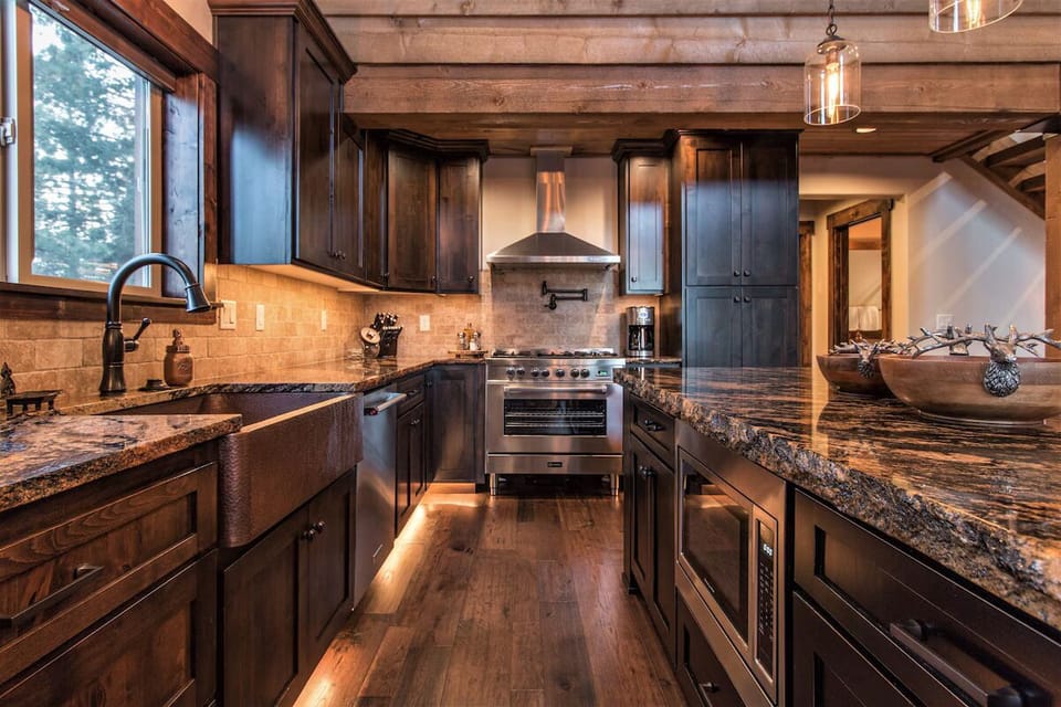 Gourmet kitchen with granite counters, copper sink, and gas range