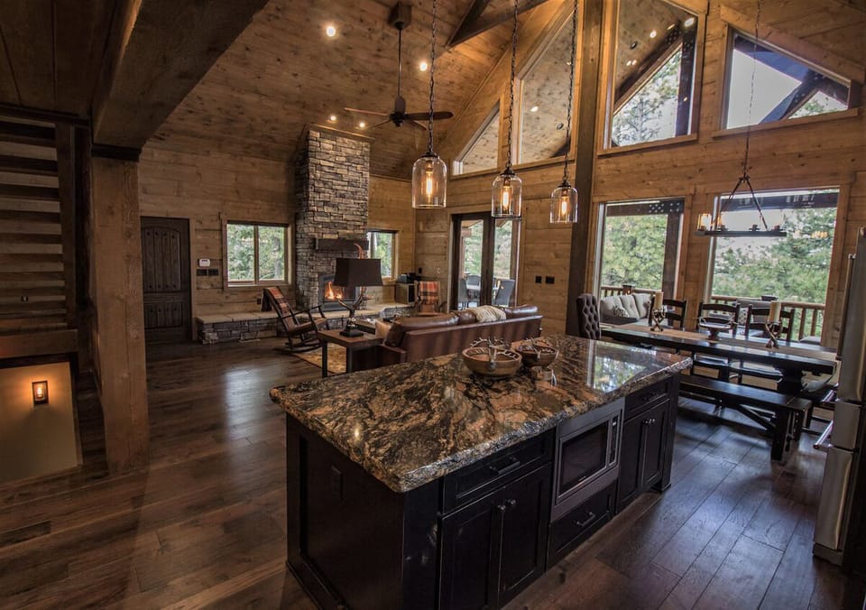 Open layout connects kitchen, dining, and great room with forest views