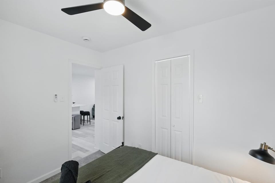 Guest bedroom featuring a twin bed, closet, and dedicated workspace.