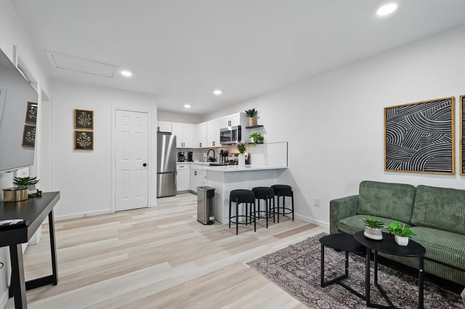 Open-concept living room and kitchen with a breakfast bar and modern finishes.