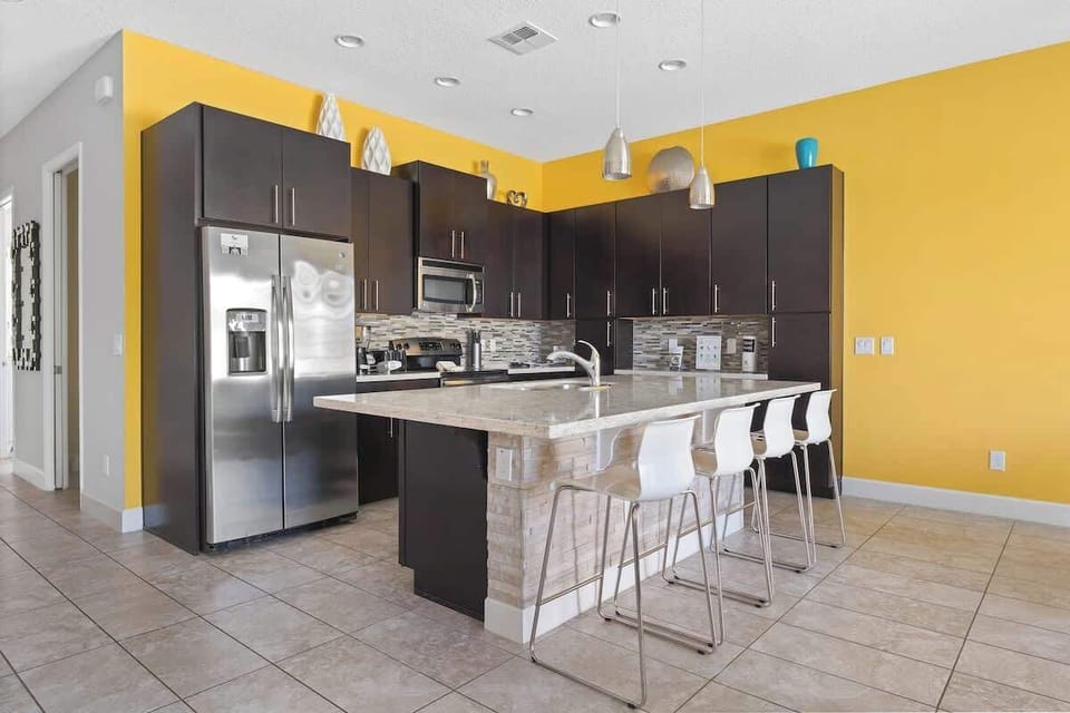 This lovely kitchen with stainless steel appliances, and a modern and beautiful backsplash. Connected to the living and dinning area,  also offers an amazing pool view.
