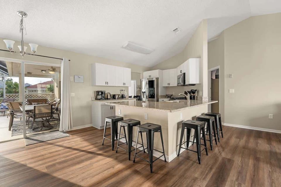 A spacious kitchen with modern appliances, and a beautiful view of the pool.