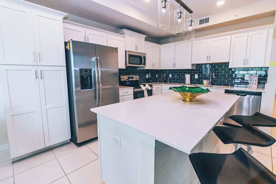 Experience culinary convenience in this modern, fully equipped kitchen, where sleek design meets functionality for effortless meal preparation and dining enjoyment.