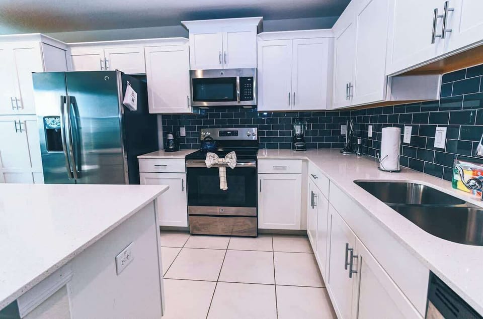 Experience culinary convenience in this modern, fully equipped kitchen, where sleek design meets functionality for effortless meal preparation and dining enjoyment.