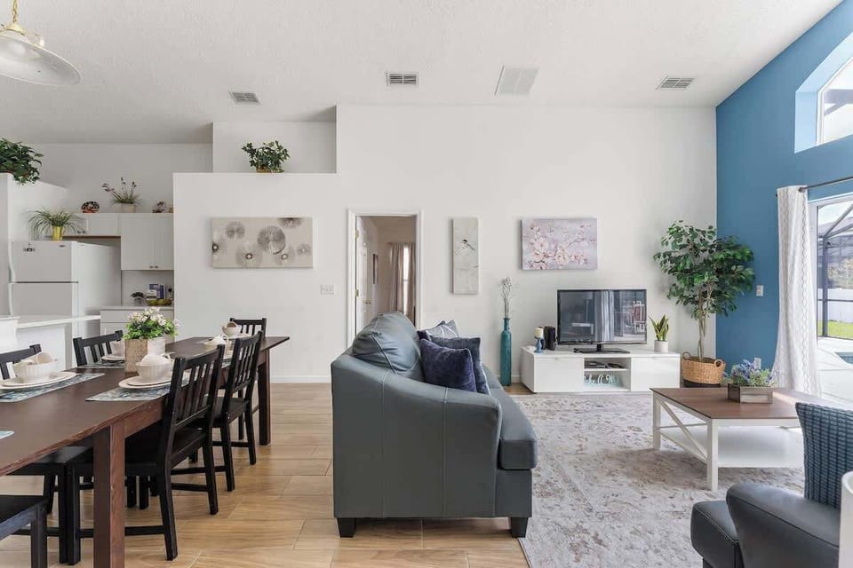 Harmonic and pleasant living room with a soothing blue wall and a stylish leather couch set.