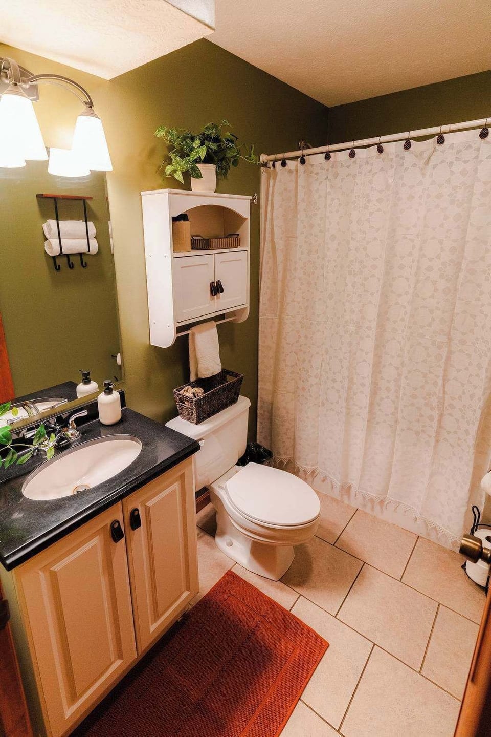 Bathroom Retreat: Enjoy modern amenities and serene green walls for a refreshing stay!