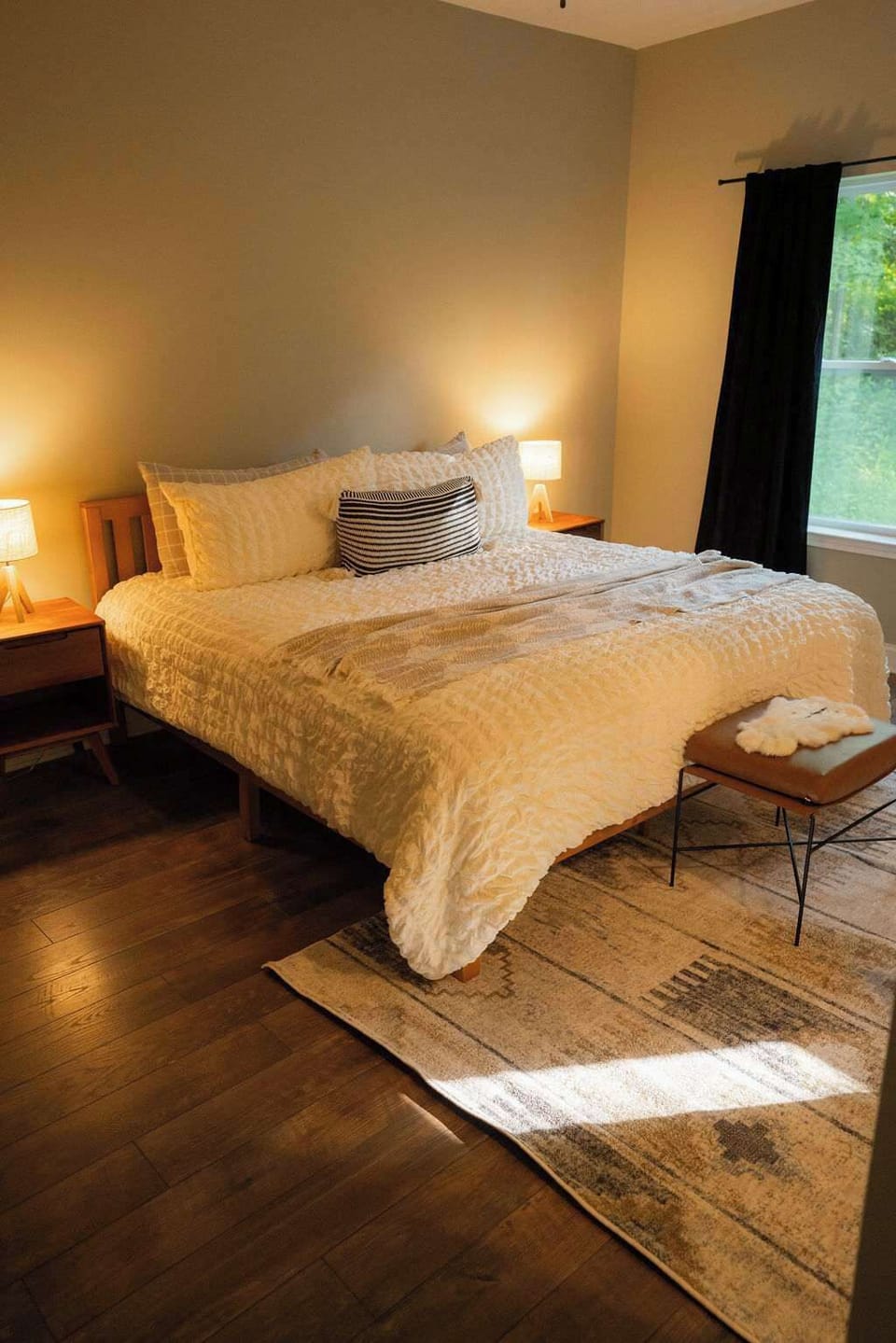 Charming Bedroom: Relax in style with a plush bed and warm lighting, perfect for sweet dreams!