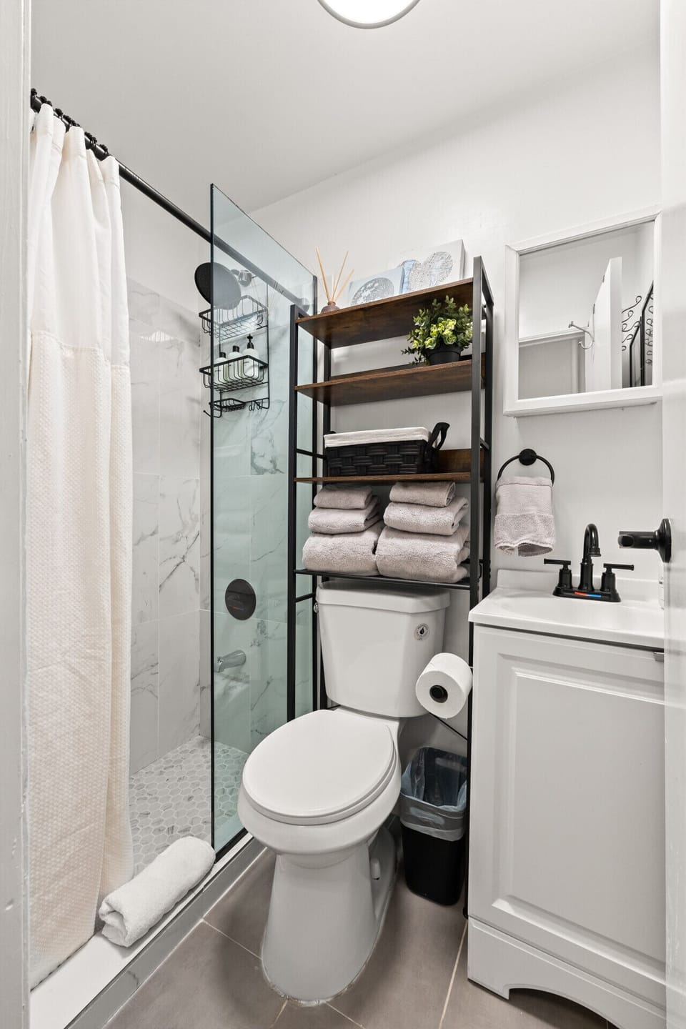 Fresh towels, clean finishes, and a modern shower make this bathroom a calm spot to refresh and relax.