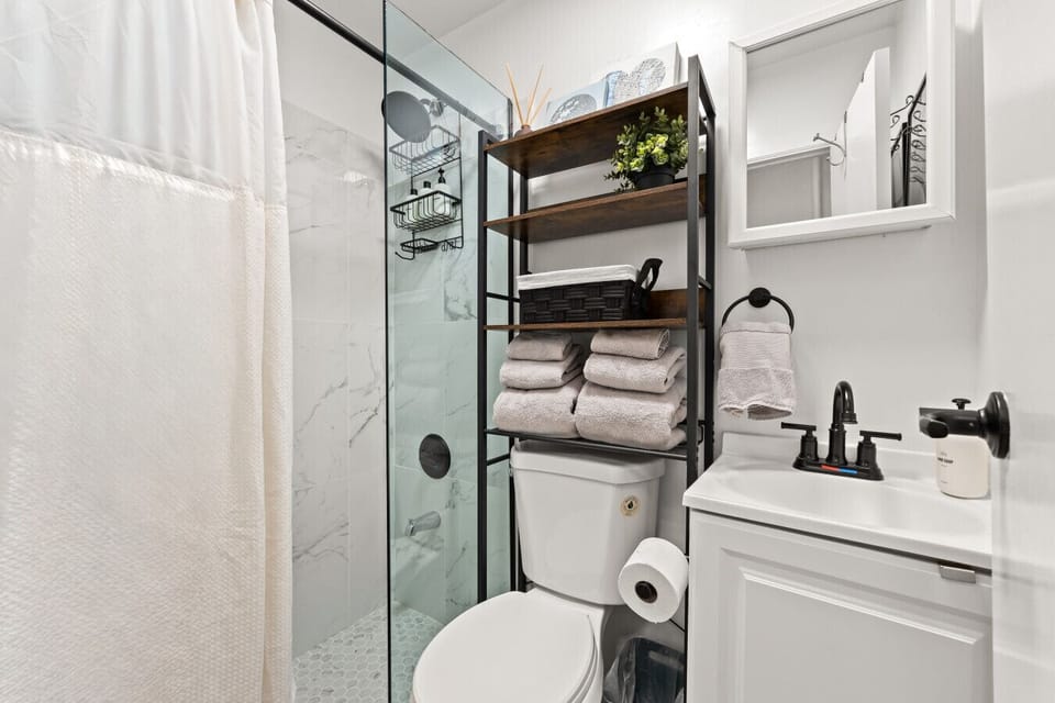 A well-kept bathroom with ample storage, soft towels, and a clean shower—everything you need in one tidy space.