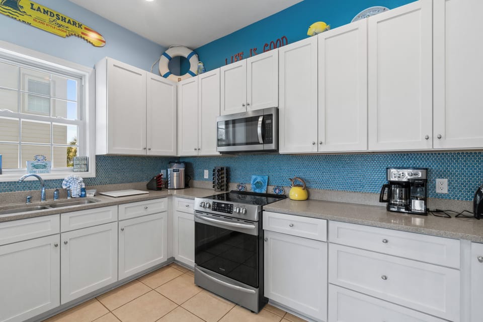 Whip up coastal feasts in your fully-equipped kitchen, featuring cheerful teal accents and modern appliances for memorable vacation meals.