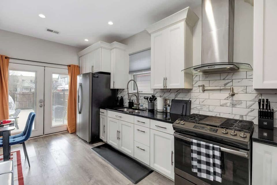 Our kitchen features a sleek stove with a range hood, ensuring a clean and fresh cooking environment.