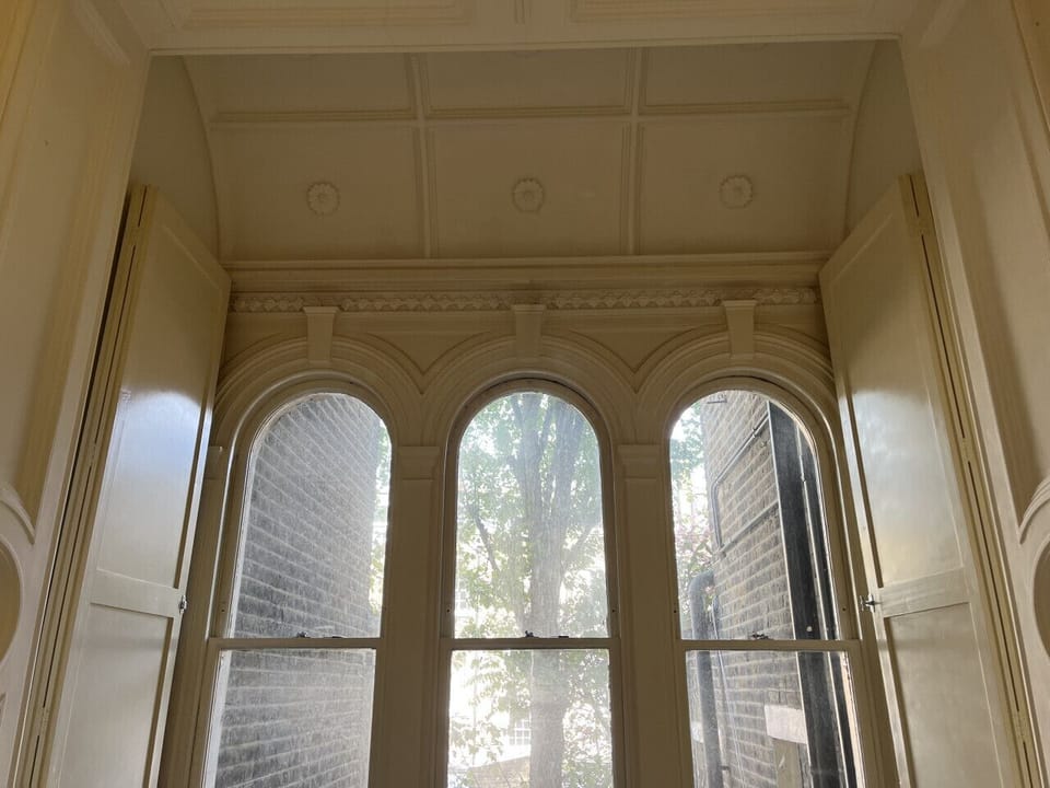 The arched windows and original ceilings in the twin bedroom