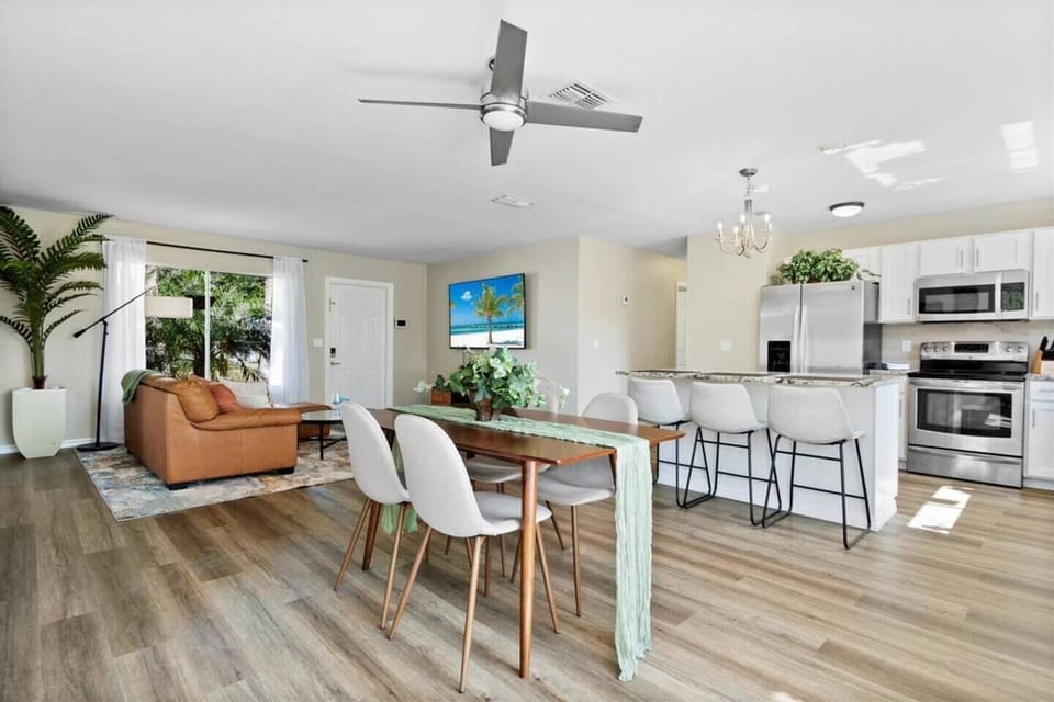 Dining area surrounded by family entertainment room and open kitchen 