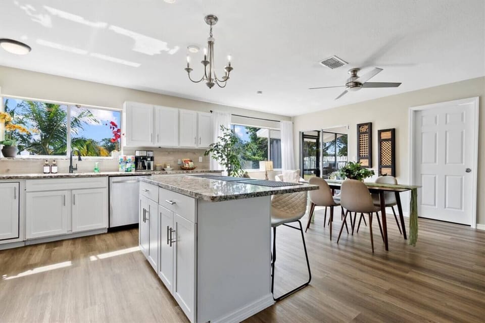Modern kitchen with granite, white cabinets, stainless appliances