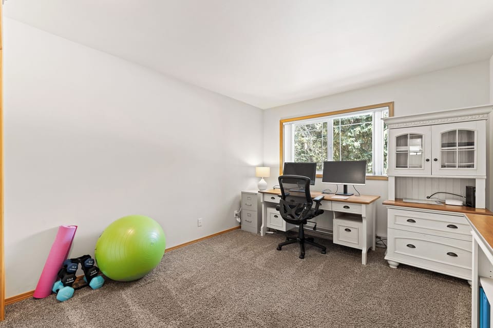 Office upstairs with a desk, chair and 2 monitors.