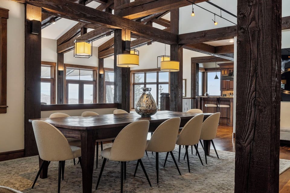 a long dining table in an elegant dining room with mountain views