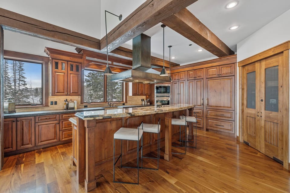 a view of a gourmet kitchen with marble countertops and a view of the mountains