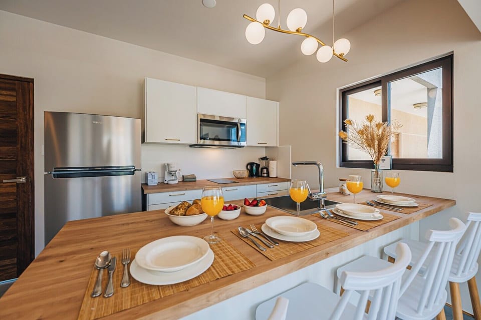 Modern kitchen and dining space featuring sleek appliances, a spacious island, and a bright ambiance—ideal for sharing meals together.