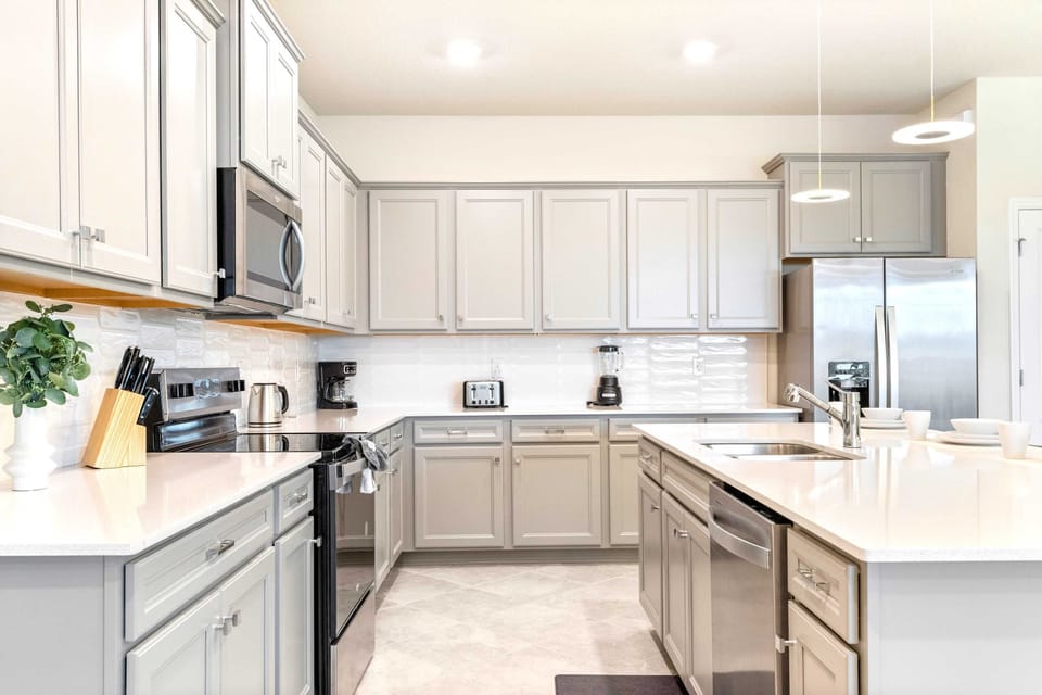 Bright, modern kitchen with full amenities, island seating, and sleek finishes