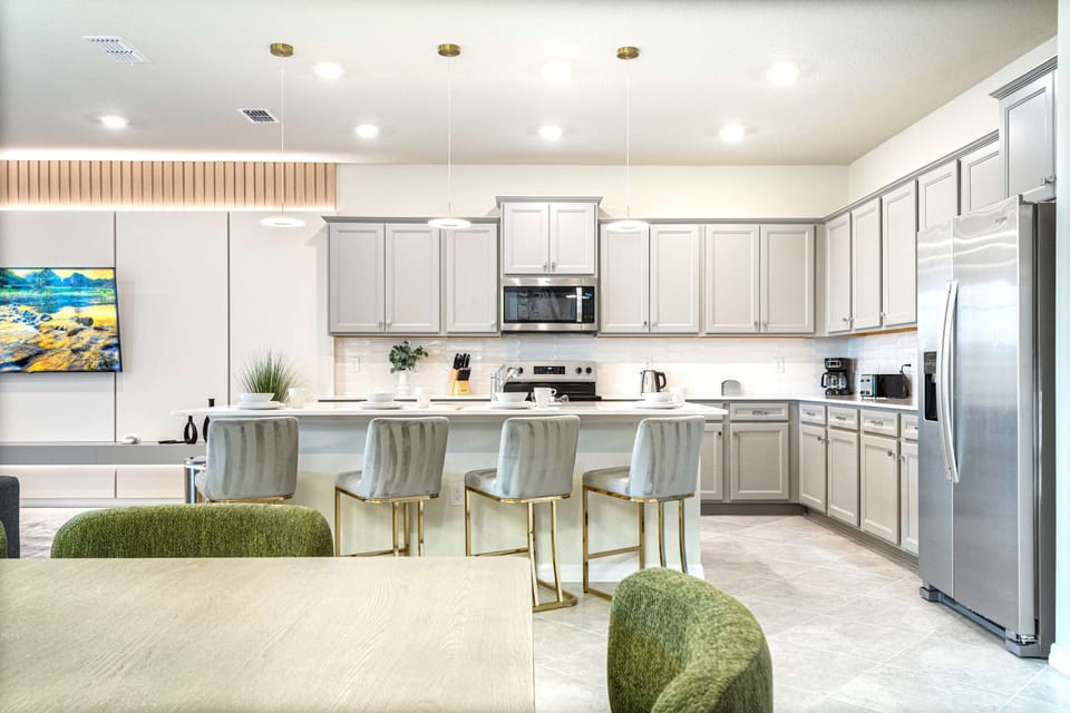 Gourmet kitchen with sleek appliances, spacious island, and stylish seating