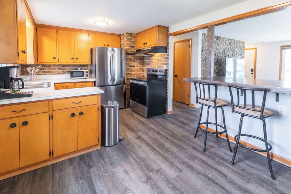 A shot capturing the kitchen and its open counter area with seating for six stools, creating a seamless flow between the kitchen and living room. Perfect for casual dining, chatting, or enjoying a drink while staying connected with the living room. 