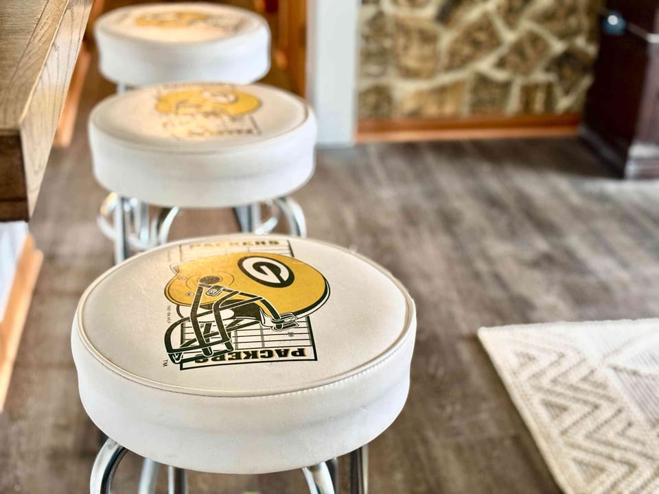 Sit back and enjoy game-day vibes on these Packer-themed stools at the kitchen counter! Perfect for meals, snacks, or drinks with friends and family while staying just steps from Lambeau Field and the Resch Center in Green Bay.”