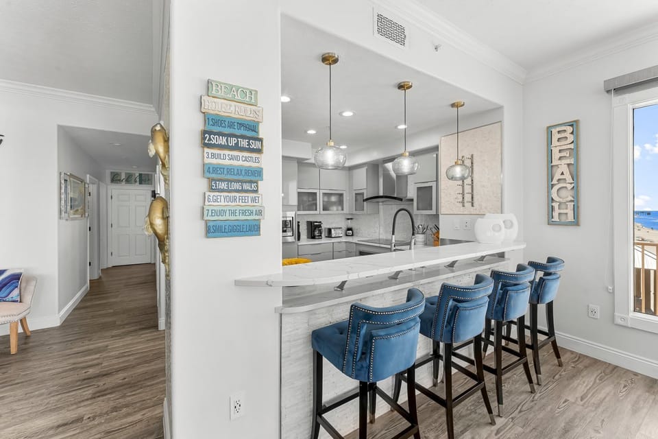 Modern kitchen with a breakfast bar and blue upholstered stools.