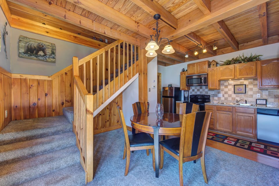Warm wood beams frame your cozy dining space, where you'll gather for meals beneath rustic charm and mountain-inspired decor.