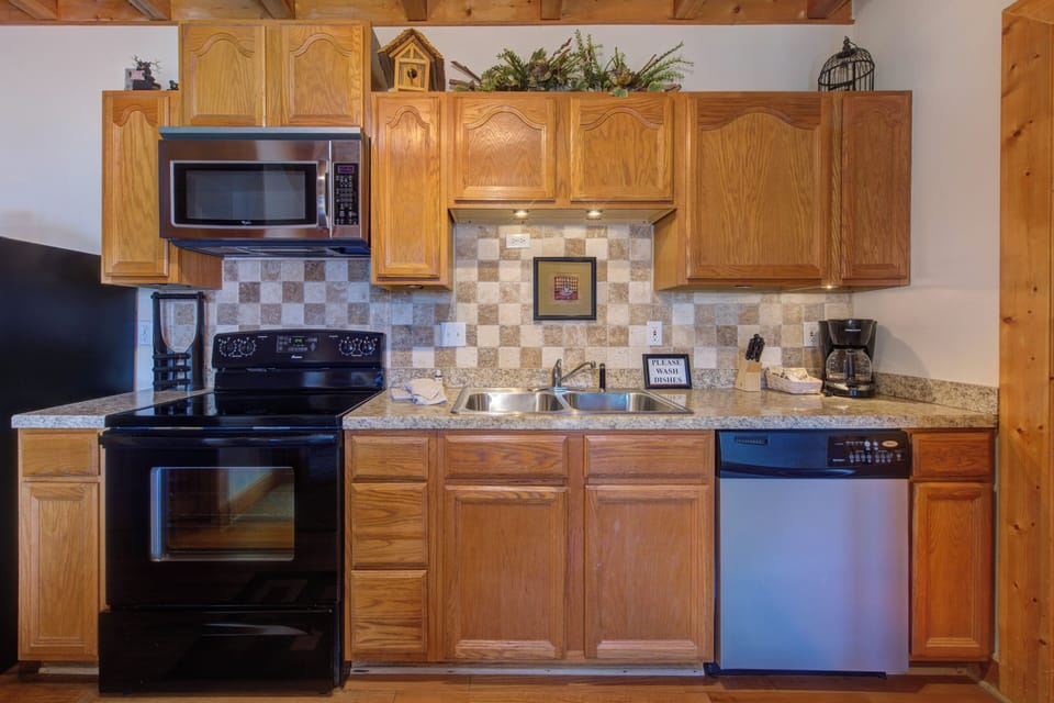 Cook your favorite meals in this fully-equipped kitchen with granite counters, stainless appliances, and charming rustic wood cabinets.