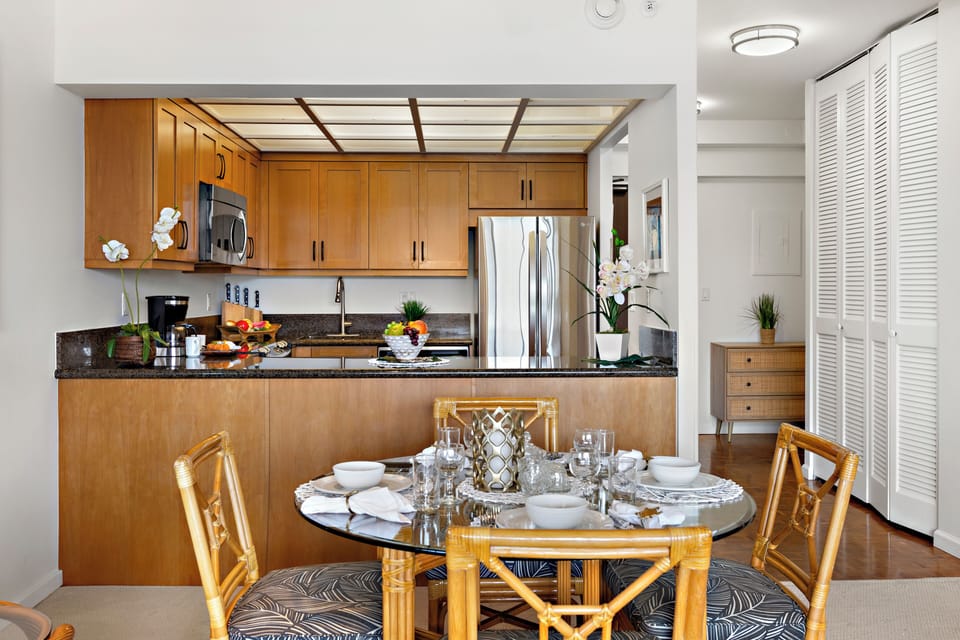 Bright and inviting open-concept kitchen featuring warm wood cabinetry, sleek granite countertops, and a spacious island that flows seamlessly into the living and dining areas. Perfect for entertaining or relaxing in comfort.