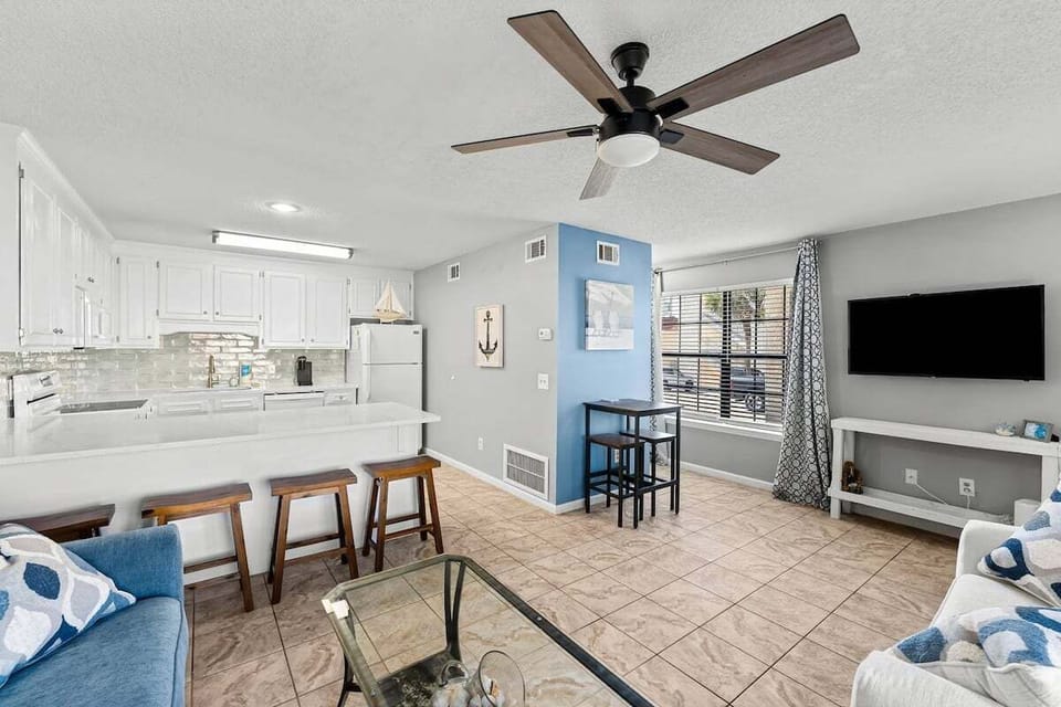 Open concept living area - kitchen, living room, bar seating & bistro dining set.