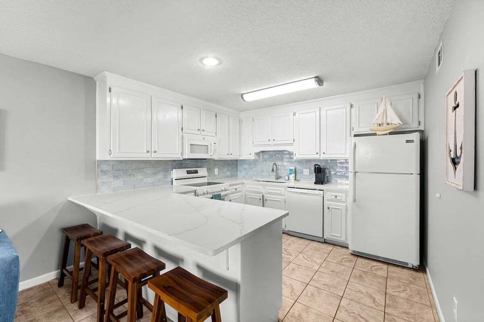 Fully equipped, recently remodeled kitchen with quartz countertops & tasteful subway tile backsplash