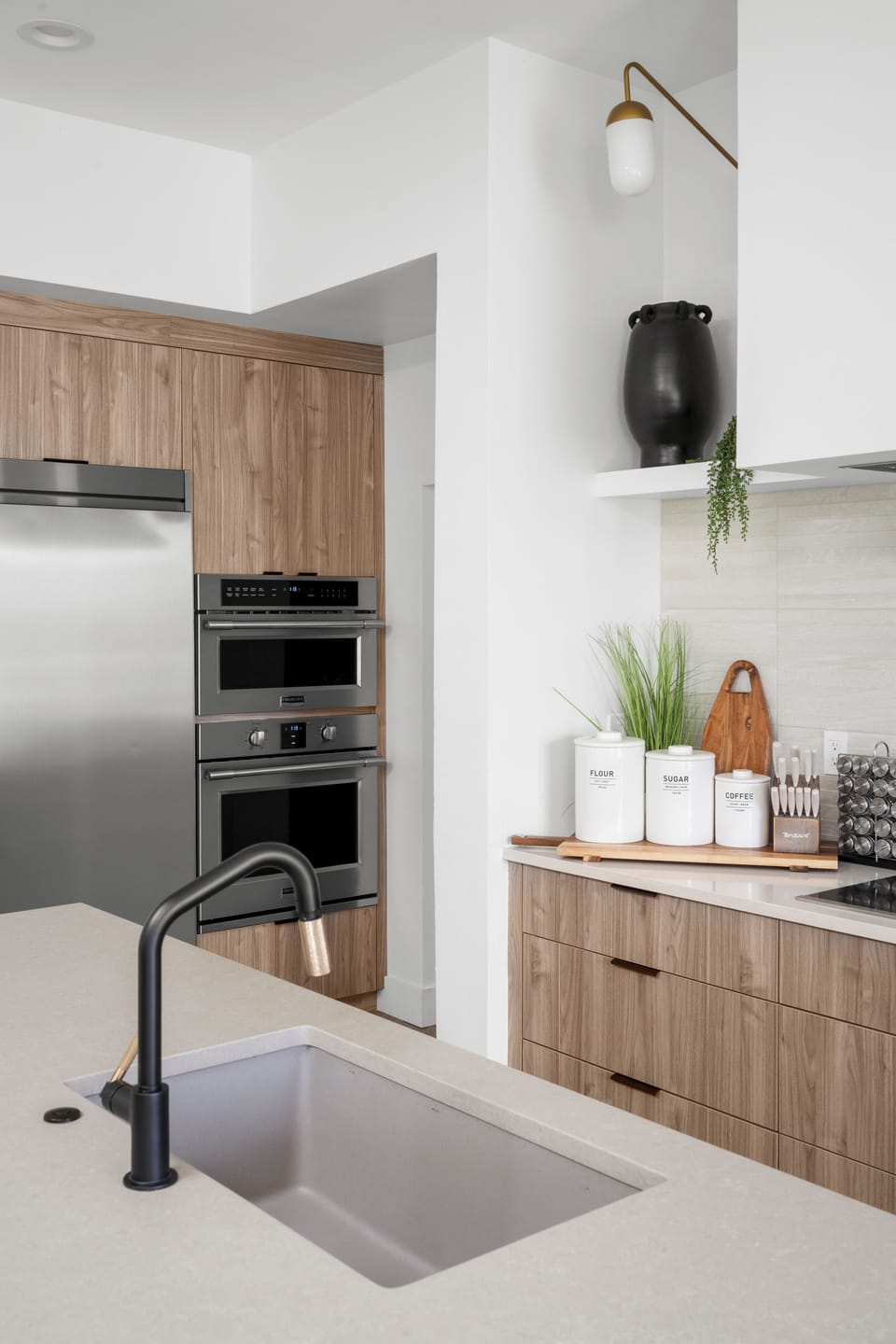 Modern kitchen with double ovens, island sink, & coffee station