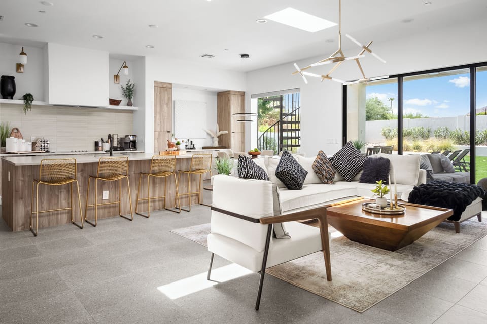 Open kitchen, island seating, luxe sofas, & indoor-outdoor vibe