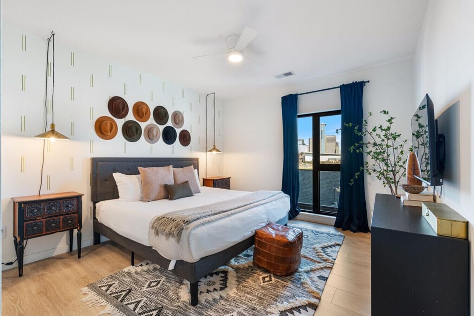 Primary Bedroom: King bed with stunning city views, designer furnishings and en-suite bathroom. Bathroom includes a dual vanity and shower/tub combo.