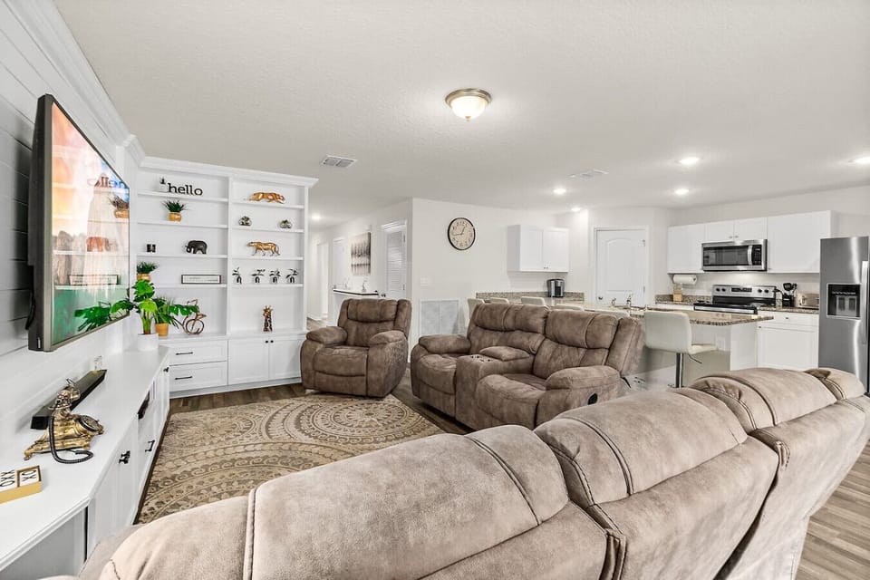 Bright and airy living space with comfortable seating and a large smart TV