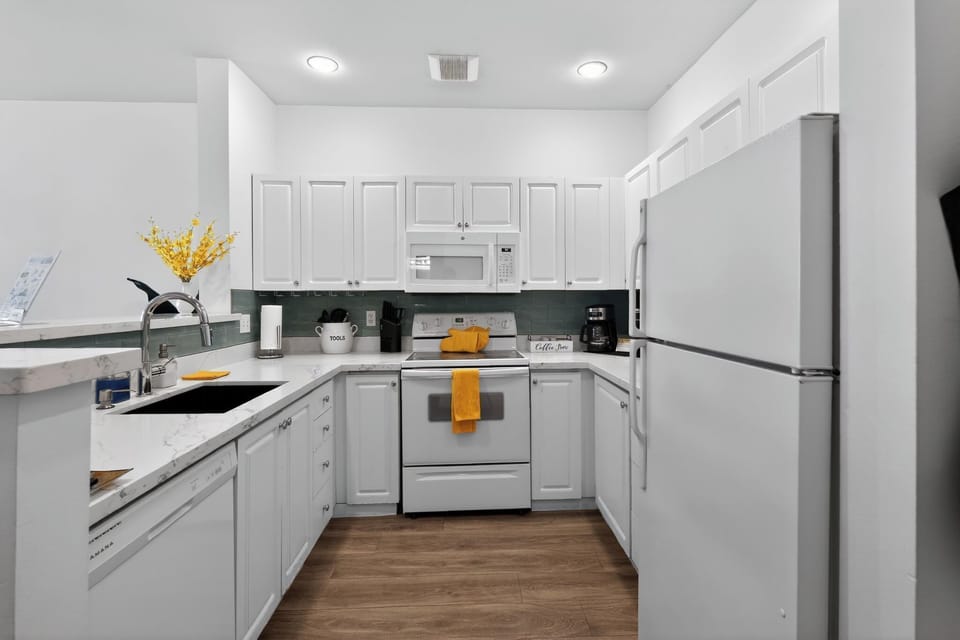 Bright U-shaped kitchen with quartz counters & full appliances