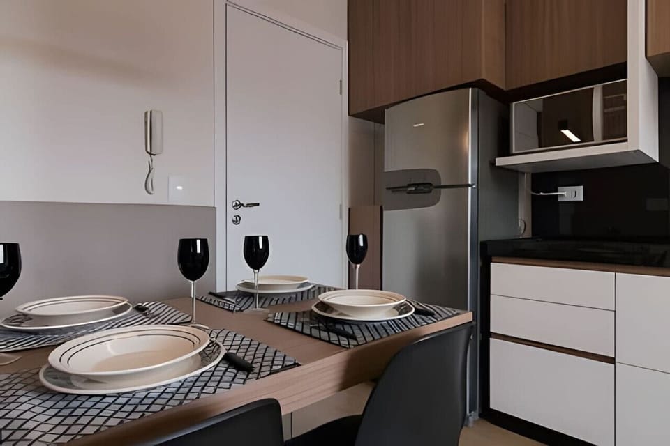 Cozinha - Geladeira, micro-ondas, armários e mesa 4 lugares.