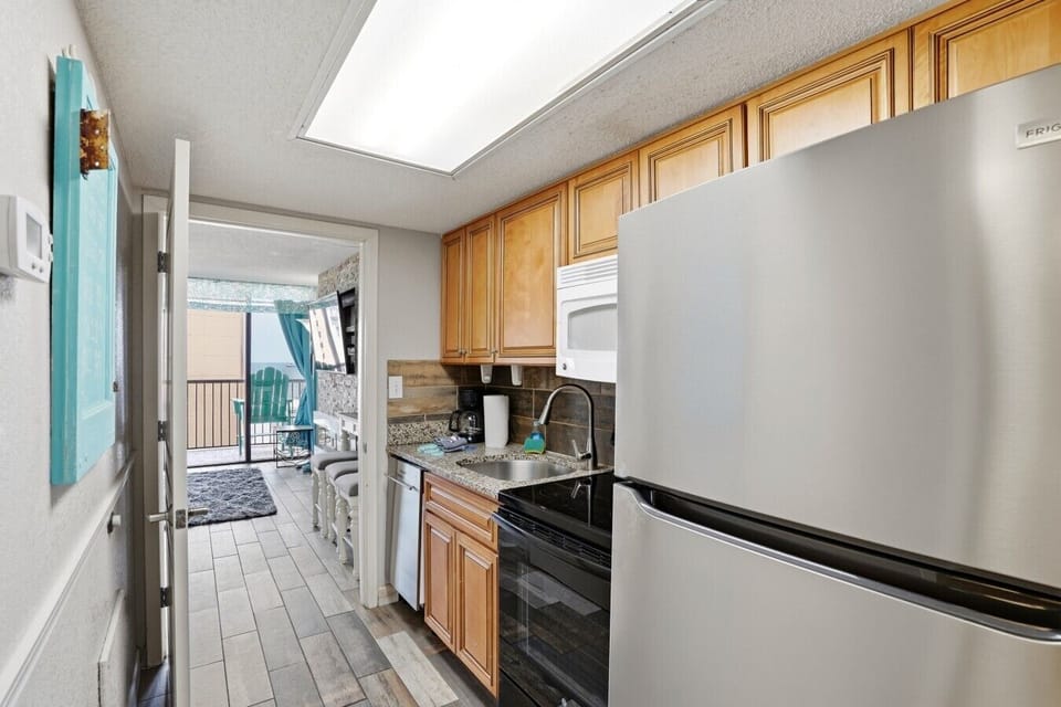 Enjoy a fully equipped kitchen featuring a full-size fridge, stove, oven, microwave, sink, dishwasher, and generous cabinet space—ideal for extended stays. Includes essentials like a coffee maker, blender, and toaster for added convenience.