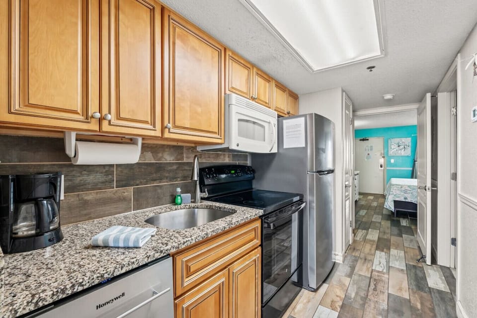 Full Kitchen with dishwasher, full-sized refrigerator, sink, stove, oven, microwave, toaster, and drip coffee maker.  Also features granite counter tops and plenty of cabinet storage space.