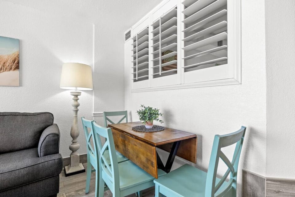 Table for four with expandable seating brings oceanfront dining to every meal in this bright, coastal-styled space.