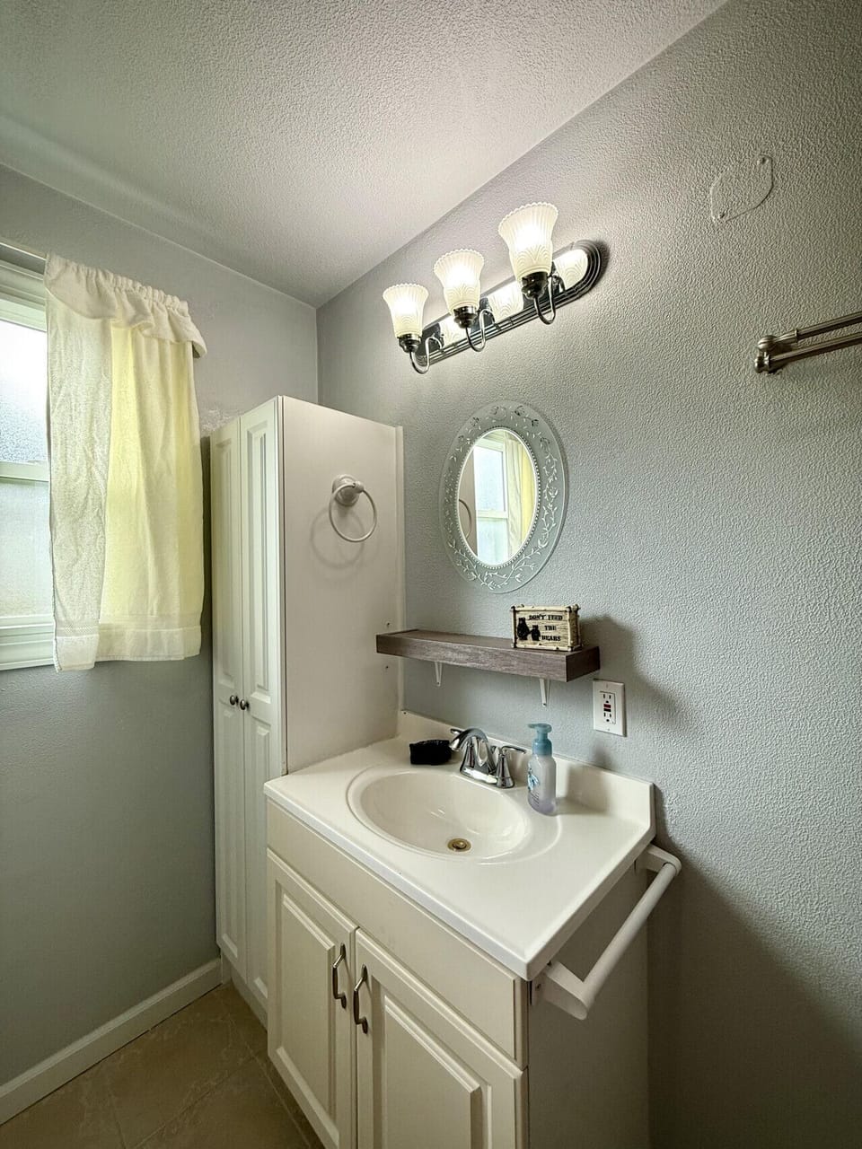 Bathroom sink, storage, and window.