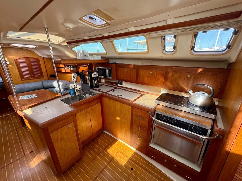Wood galley with gas range, oven, and marina views through the ports