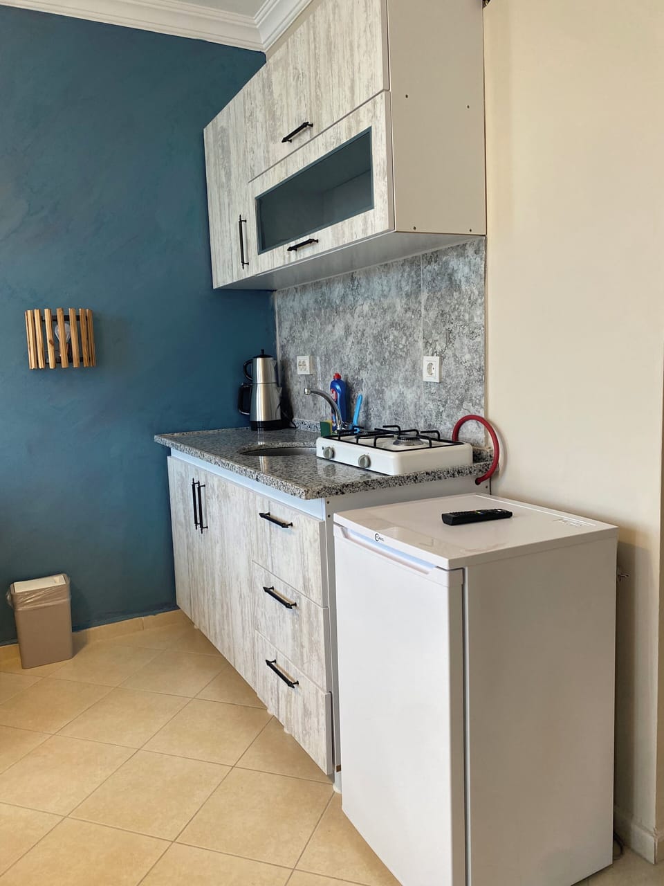 Mini-fridge, stovetop, cookware/dishes/utensils, dining tables