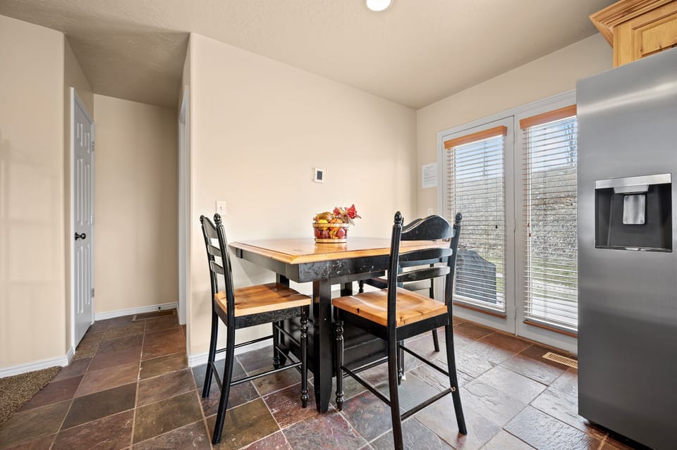 Nearby, a dining table for three offers a more intimate space to enjoy home-cooked dinners or late-night card games.