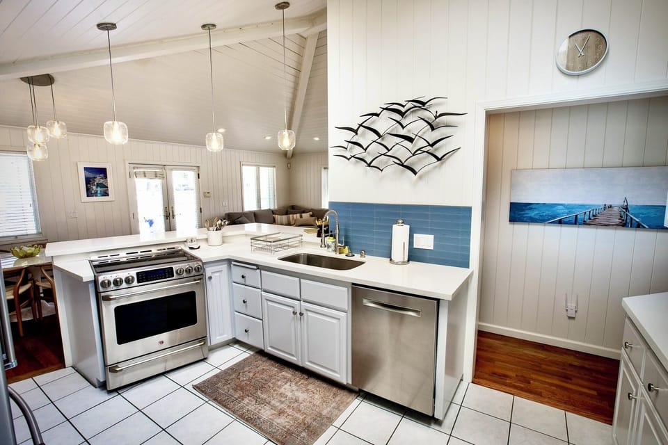 Bright, airy, and fully equipped, this kitchen is the heart of the home. Featuring vaulted ceilings with skylights, sleek pendant lighting.