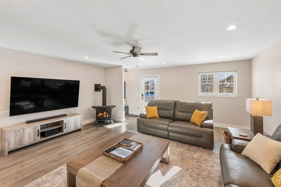 Spacious living room with large leather recliners and 75" TV.
