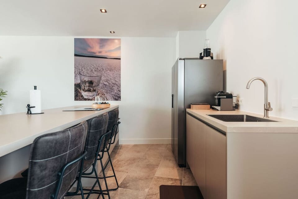 This modern kitchen layout balances simplicity and style. With cozy bar seating, clean counters, and soft natural light, it’s designed for both quiet mornings and lively gatherings.