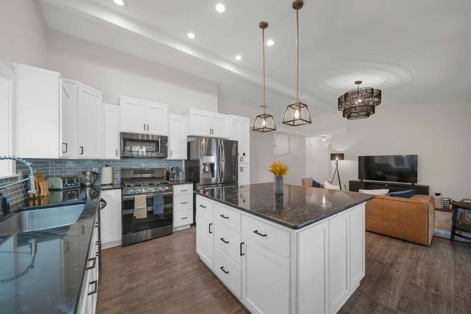 This modern kitchen interior boasts sleek finishes and all the necessary high-end appliances for your stay.