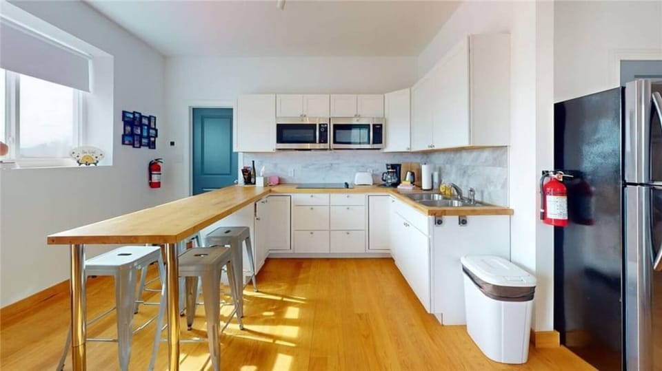 A bright, modern kitchen features sleek countertops and island seating. Perfect for your morning coffee or evening wine. 
